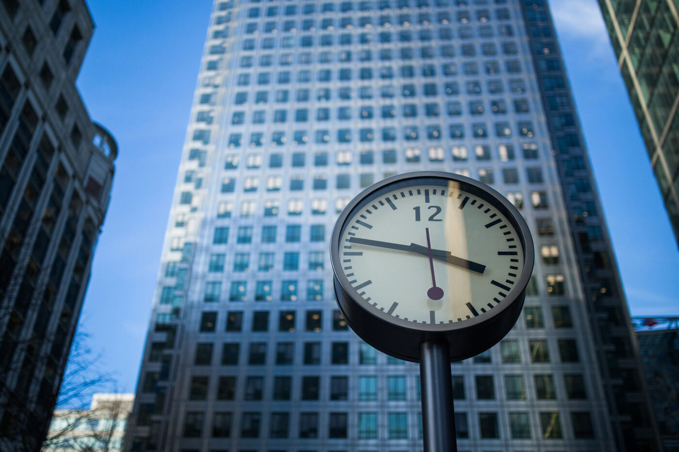 A street clock in front of office towers at Canary Wharf, London